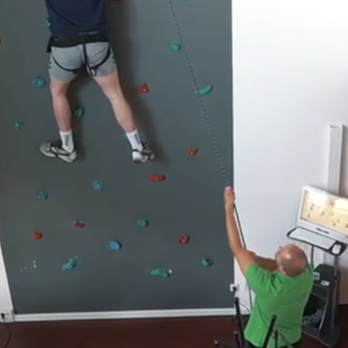 Screenshot 2025-09-25 122804 Physiotherapeut unterstützt Patienten an der Kletterwand bei einer Übung