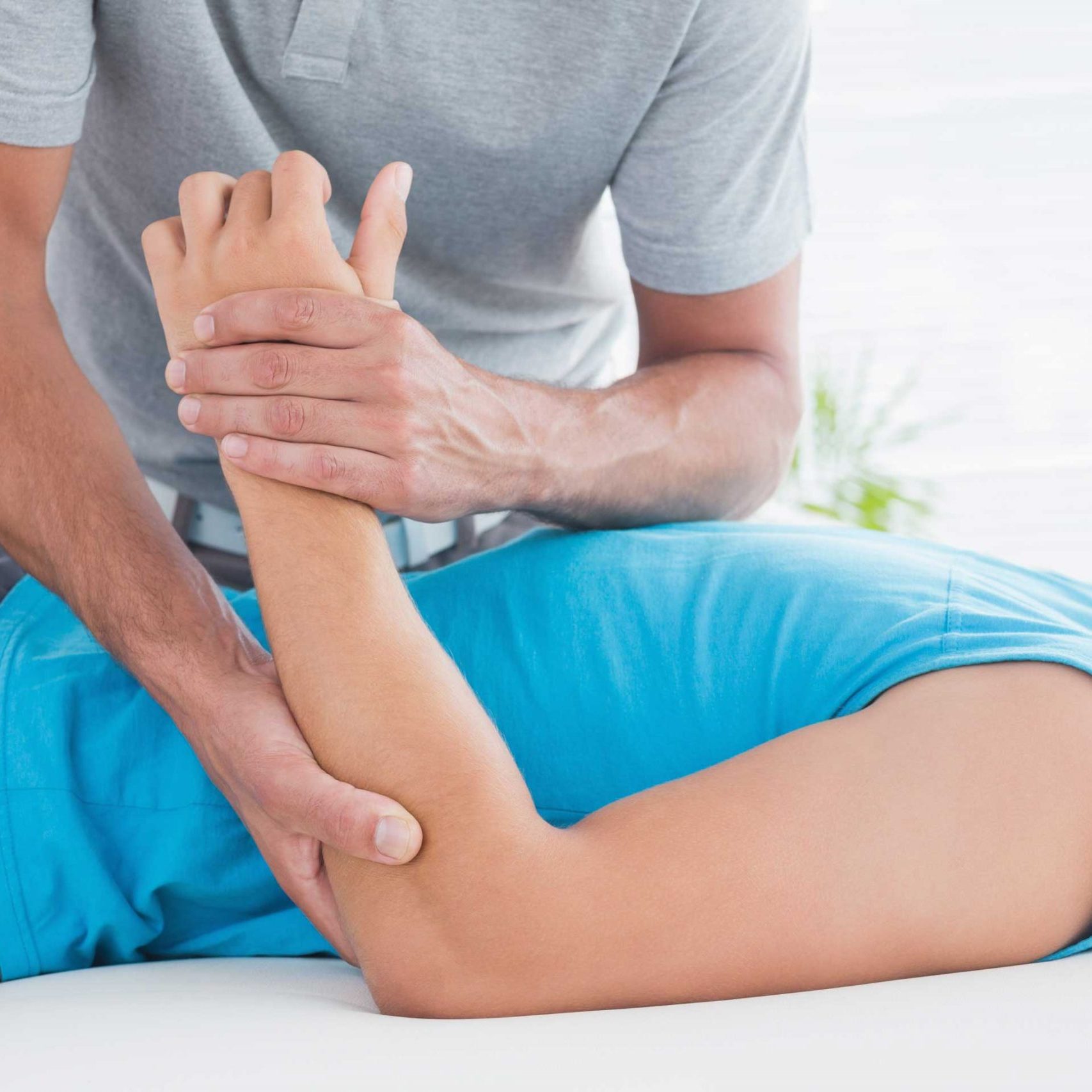doktor-der-seinen-geduldigen-arm-uberpruft Physiotherapeut arbeitet mit Patient während einer Übungseinheit